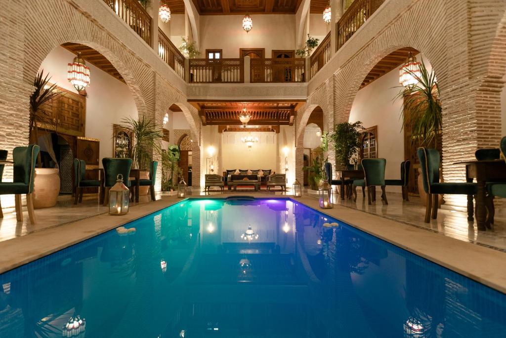 ein großer Pool in einem großen Gebäude mit großer Halle in der Unterkunft Riad Janate & SPA in Marrakesch