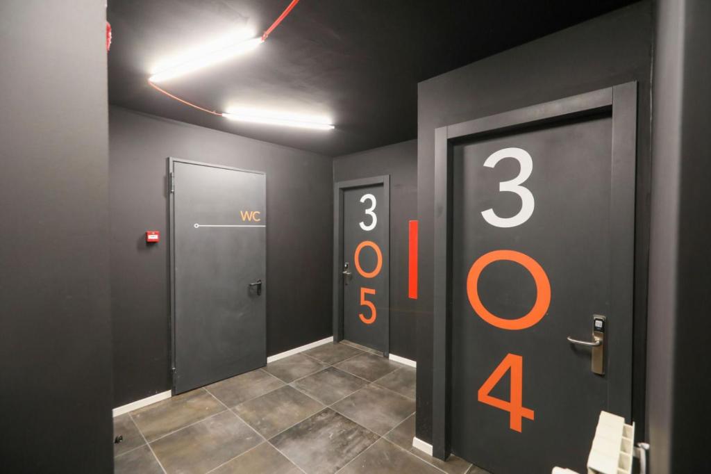 a hallway with two elevators with numbers on the wall at Hotello Hostel in Trieste
