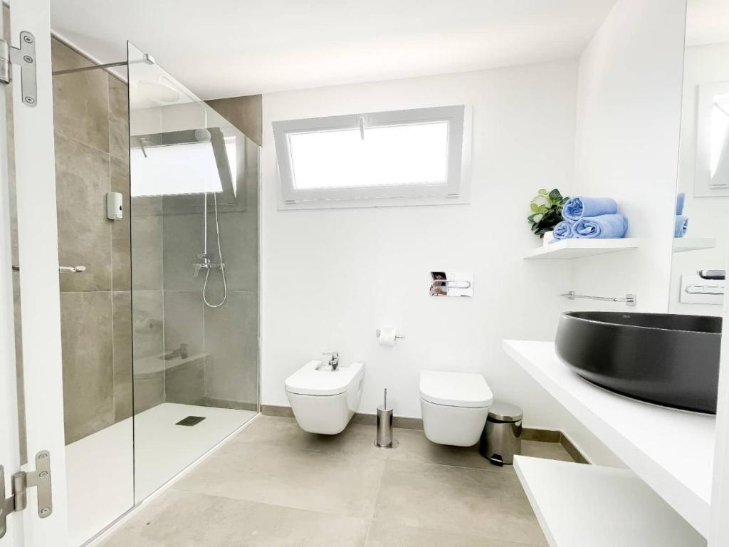 a white bathroom with a sink and a toilet at Island Home Fuerteventura in Corralejo