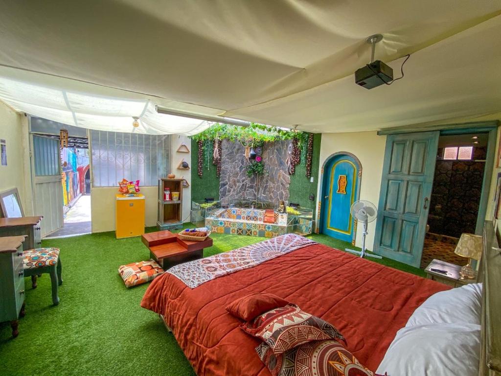 1 dormitorio con 1 cama grande en una habitación con alfombra verde en Cosmos Chill - Suite con jacuzzi y acuario en Ambato