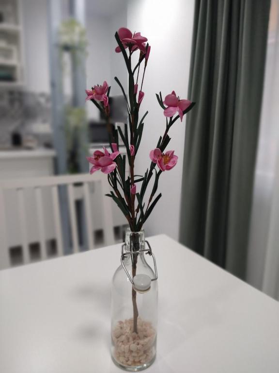 un vase avec des fleurs roses sur une table dans l'établissement Nice & Cool Studio, à Torremolinos