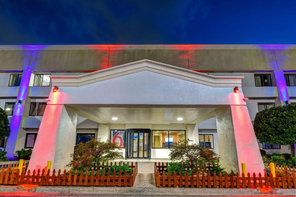 a large white building with a fence in front of it at Motel 6-Norcross, GA in Norcross