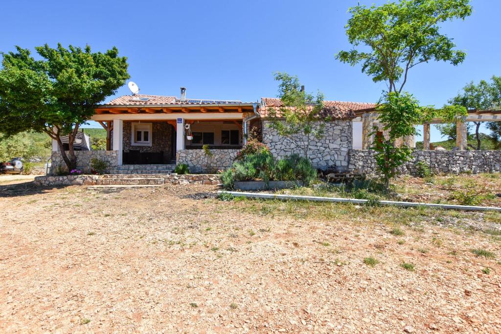 an old house with a stone wall at House Romano in Neviđane
