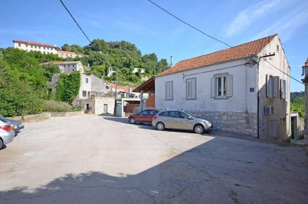 una calle con dos coches estacionados al lado de un edificio en House Marija, en Lastovo