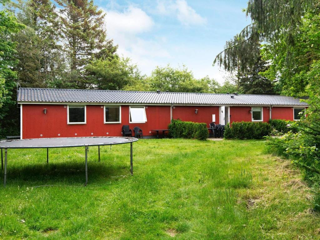 a red house with a tennis court in the yard at 20 person holiday home in Herning in Herning
