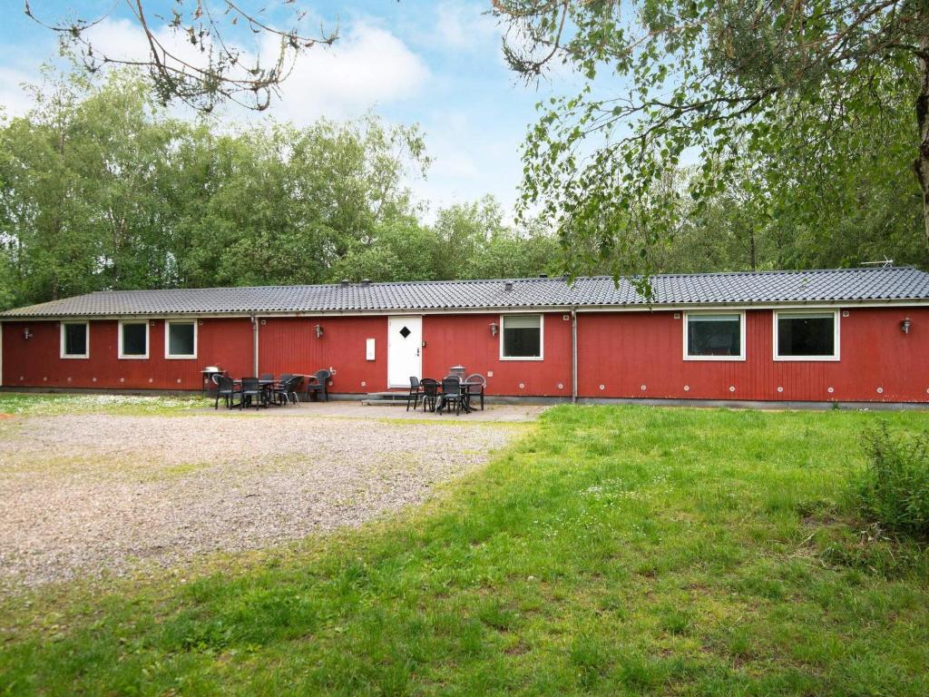 ein rotes Gebäude mit Picknicktischen davor in der Unterkunft Holiday home Herning III in Herning