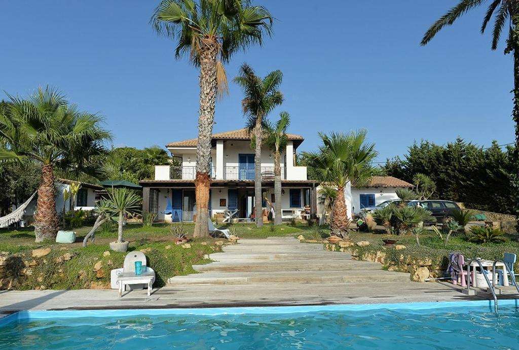 una casa con palme e una piscina di SUNSET HOUSE a San Leone