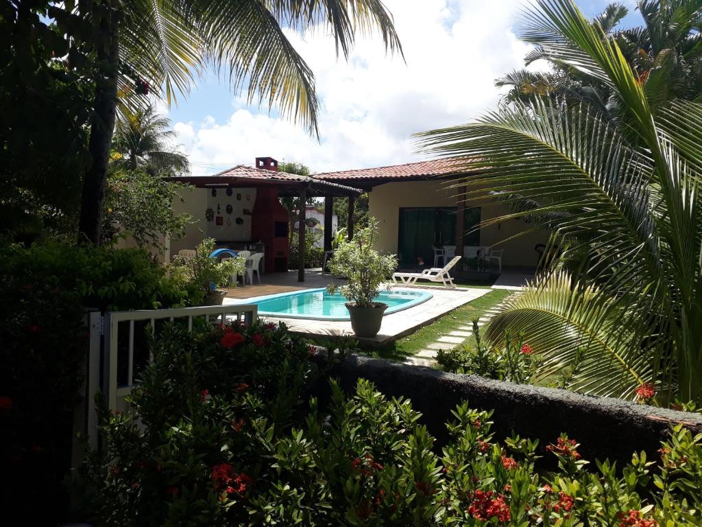 a villa with a swimming pool and palm trees at Casa na Praia dos Carneiros - Tamandaré in Tamandaré