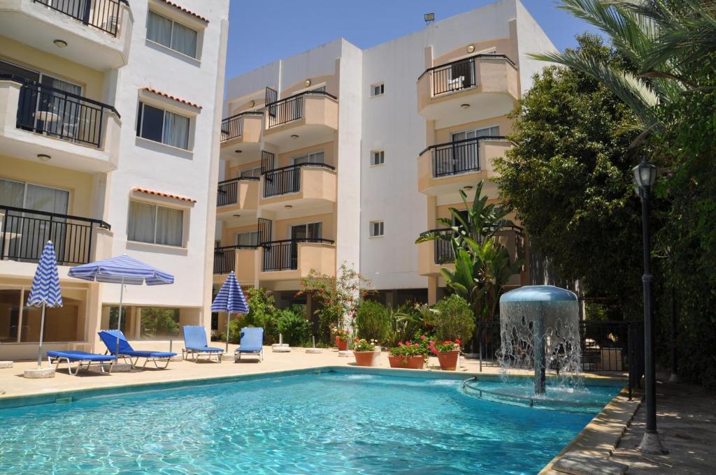 a swimming pool with a fountain in front of a building at Mariela Hotel Apartments in Polis Chrysochous