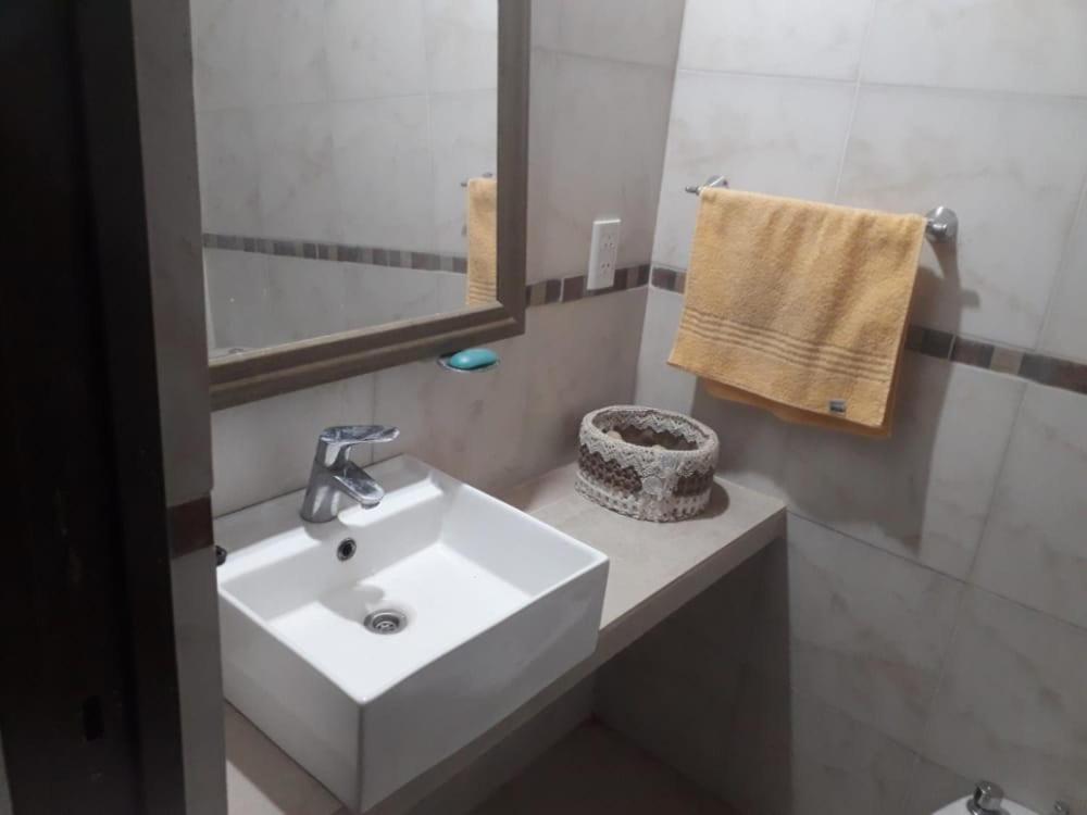 y baño con lavabo blanco y espejo. en León Apart -un dormitorio- en Corrientes