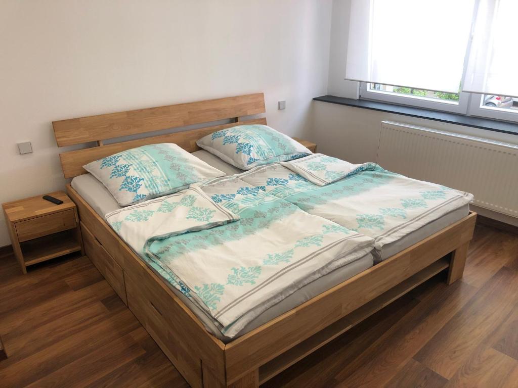 Un dormitorio con una cama con sábanas azules y blancas y una ventana en Gästehaus Jagsttal, en Möckmühl