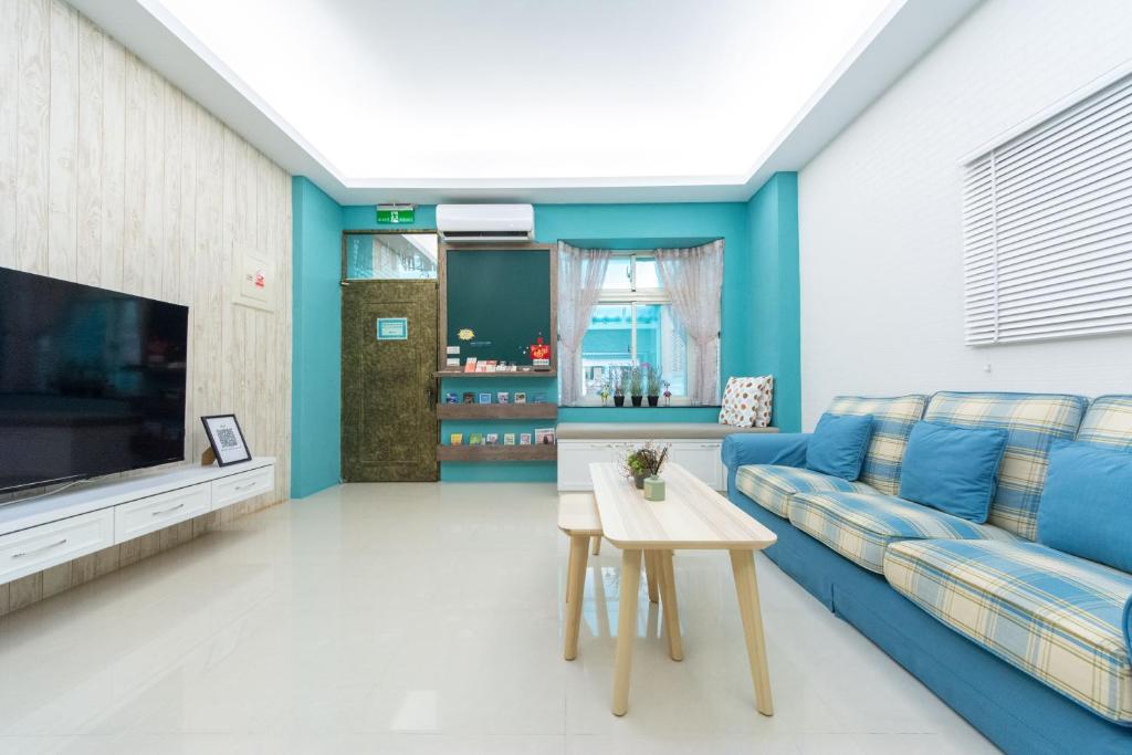 a living room with a blue couch and a tv at 向晴民宿 花蓮市包棟民宿 in Hualien City