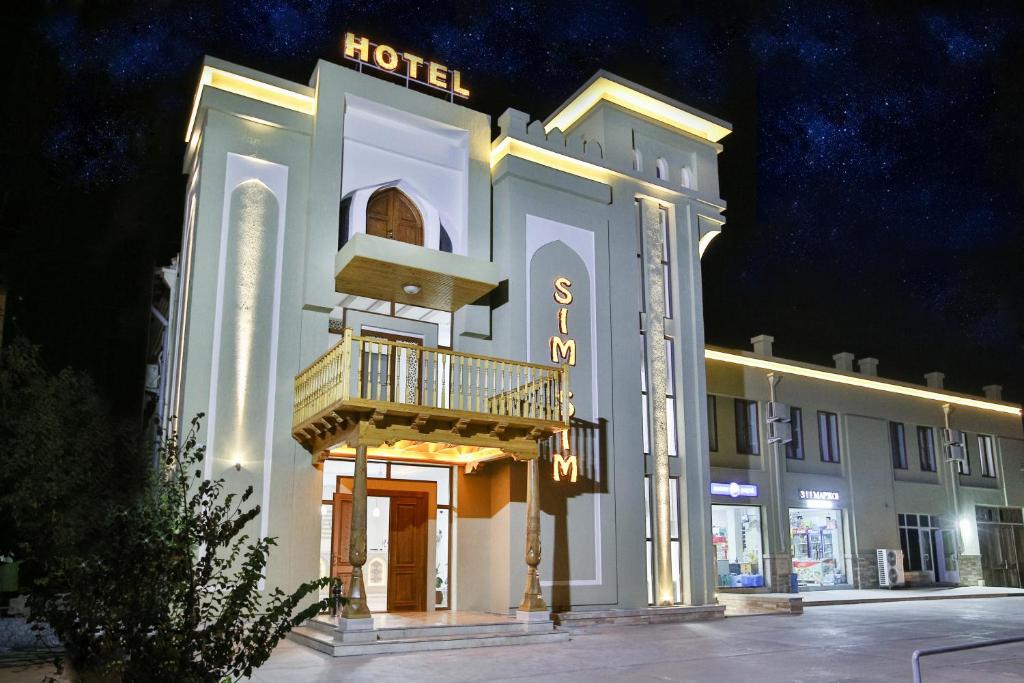 a hotel with a balcony on the side of it at sim sim bukhara in Bukhara