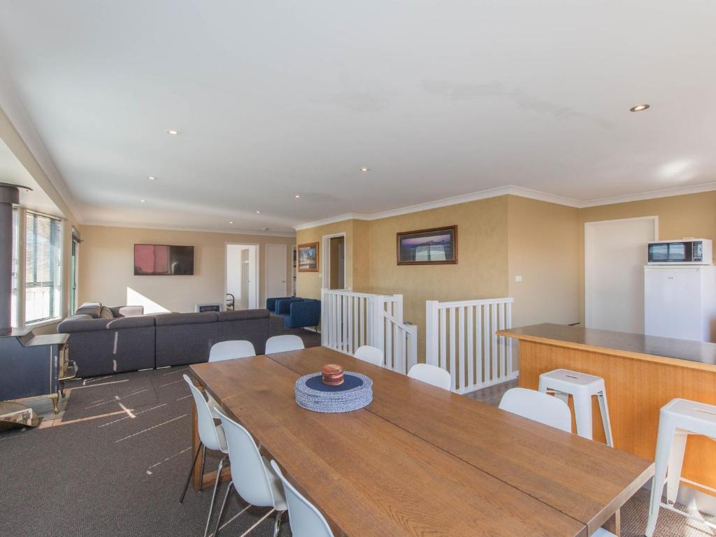 a living room with a table and a couch at Chalet De Neige 2 9 Jillamatong Street in Jindabyne