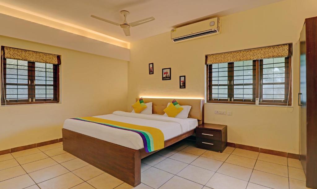 1 dormitorio con 1 cama y 2 ventanas en Itsy By Treebo - Vailankanni Natures Inn en Panaji