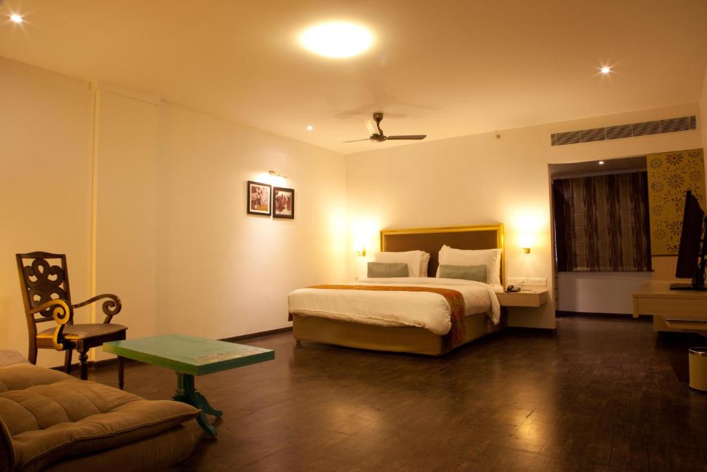 a hotel room with a bed and a couch at Hotel Sabareesh Park in Madurai