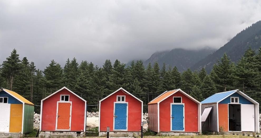 une rangée de maisons colorées devant une montagne dans l'établissement Panjkura Hotel And Resorts, à Tāl