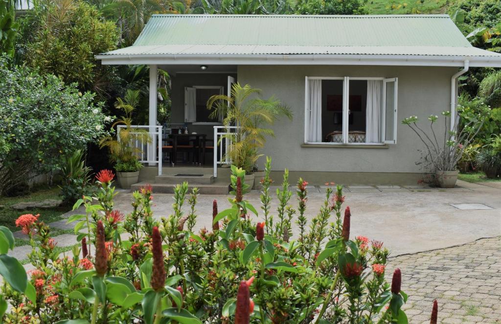 a house with a garden in front of it at Sunbird Bungalow in Anse Boileau