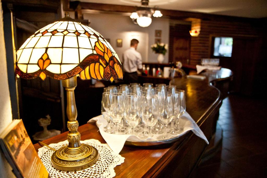 un groupe de verres à vin sur une table avec une lampe dans l'établissement Zajazd Mat, à Bełk