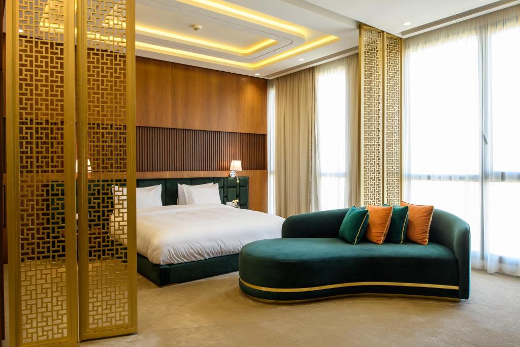 BH Appart Hotel في الدار البيضاء: غرفة فندق بسرير واريكة خضراء