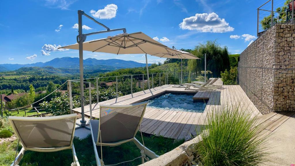 a pool with two chairs and an umbrella at Suites & Balnéo chez l'habitant - Vue panoramique sur le Vercors in Pont-en-Royans