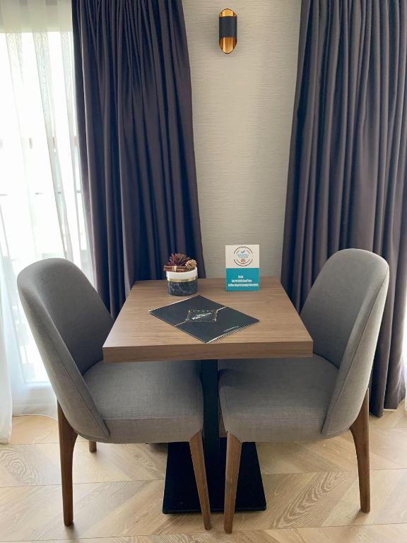 a wooden table with two chairs and a box on top at Istanbul Park Hotel in Tuzla