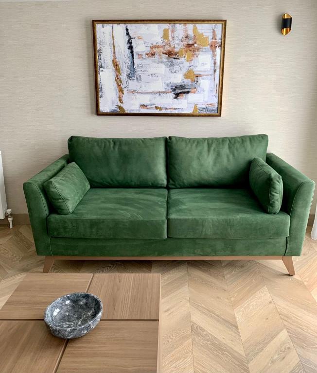 a green couch sitting in a living room at Istanbul Park Hotel in Tuzla