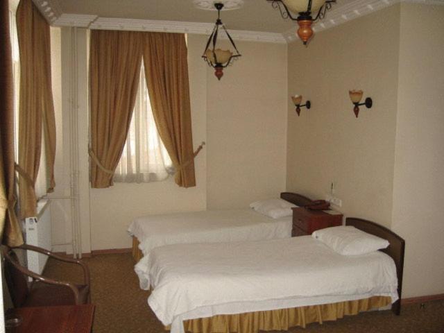 a hotel room with two beds and a window at Hotel Atasayan in Gebze