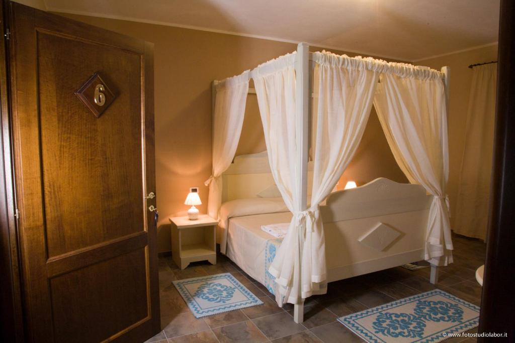 une chambre avec un lit à baldaquin dans l'établissement Agriresort Terradome, à Uta