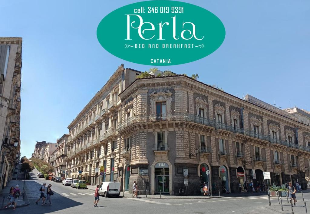a large stone building on a street in front of a building at B&B Perla in Catania