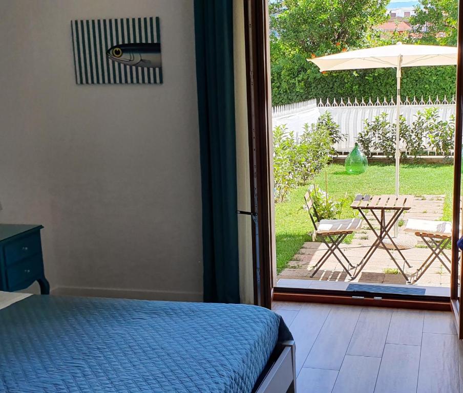 een slaapkamer met een bed en een open deur naar een patio bij Maison Ligea in Sorrento