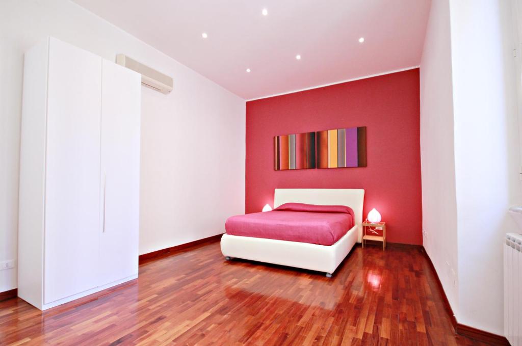 a red bedroom with a white bed and a red wall at Rome Aparts in Rome