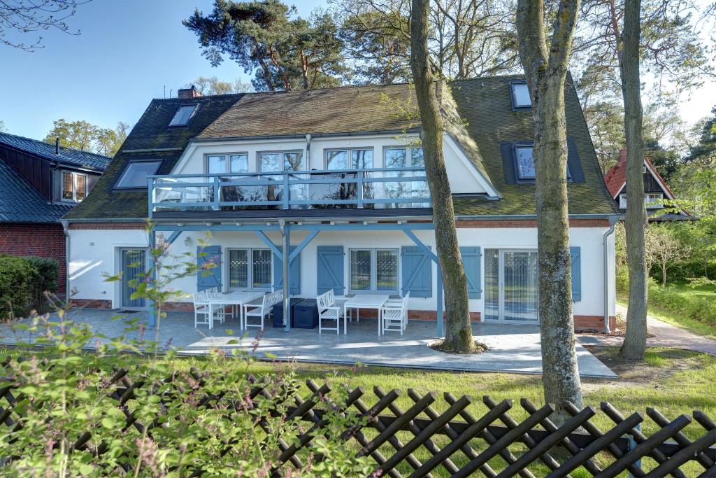a house with a wrap around porch with a deck at Strandhafer in Boltenhagen