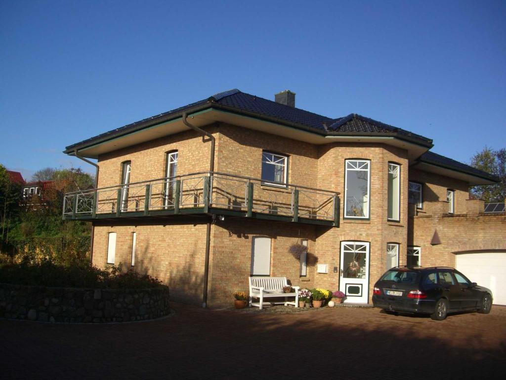 a large brick house with a car parked in front of it at Nordseeholiday in Nordhastedt