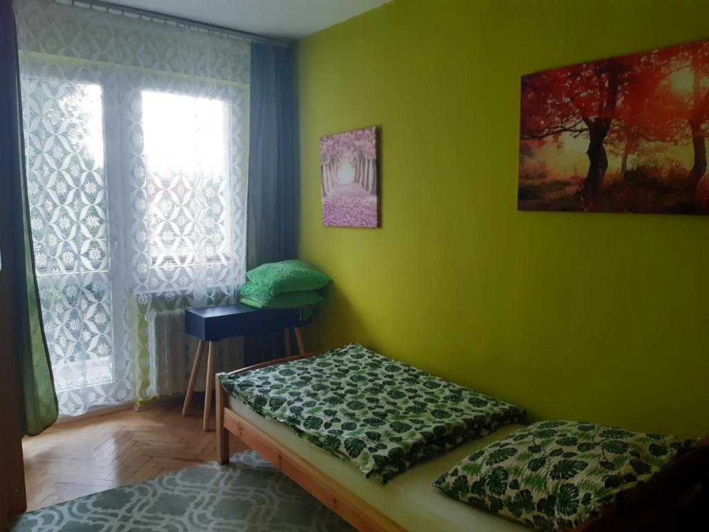 Habitación verde con cama y ventana en Mieszkanie 2-pokojowe, en Rzeszów