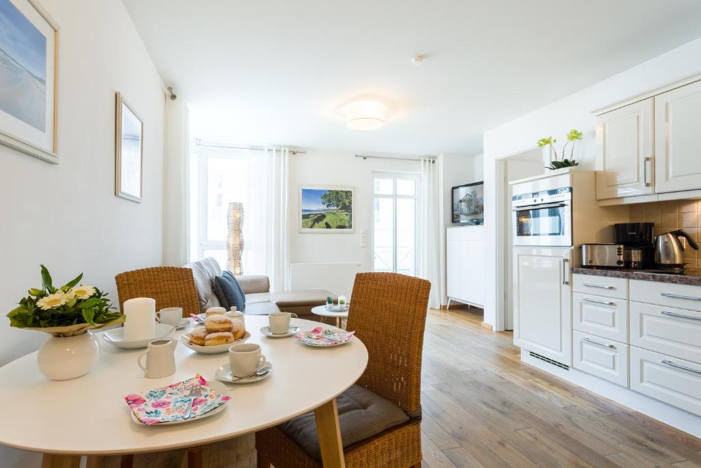 eine Küche und ein Esszimmer mit Tisch und Stühlen in der Unterkunft Seemöwe - Villa Helene mit Meerblick in Top Lage in Binz