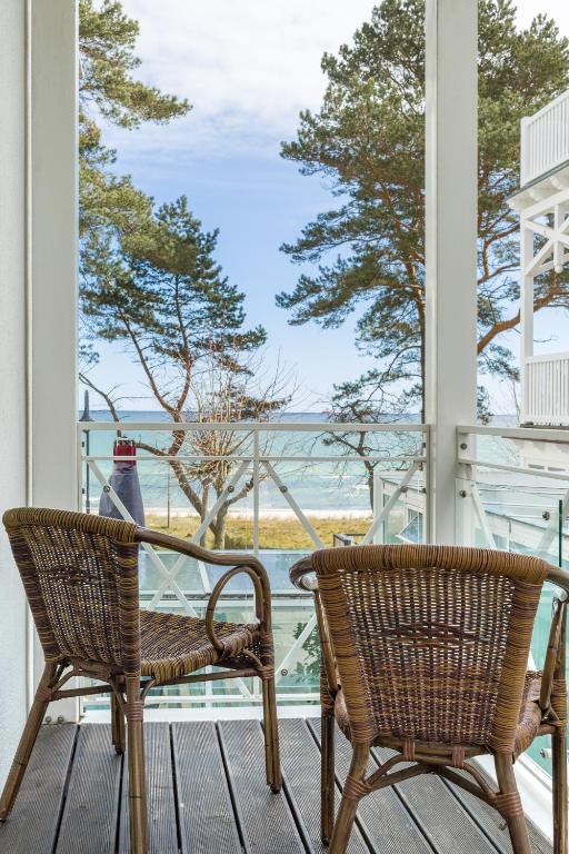 eine Veranda mit 2 Stühlen und einem Tisch sowie Meerblick in der Unterkunft Seemöwe - Villa Helene mit Meerblick in Top Lage in Binz