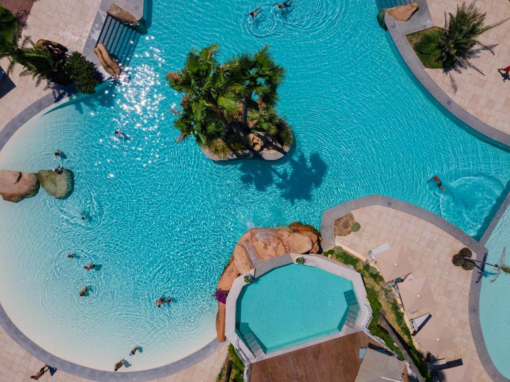 an overhead view of a pool with people in the water at Hotel Club Saraceno - Bovis Hotels in Àrbatax