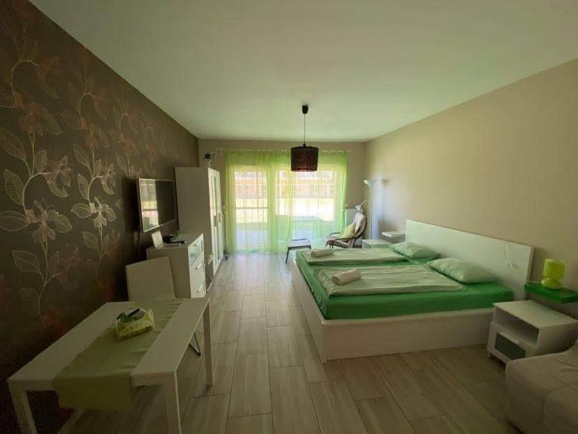 ヴァレンツァにあるTóparti Wellness Apartman Deluxのベッドルーム1室(ベッド1台、テーブル付)