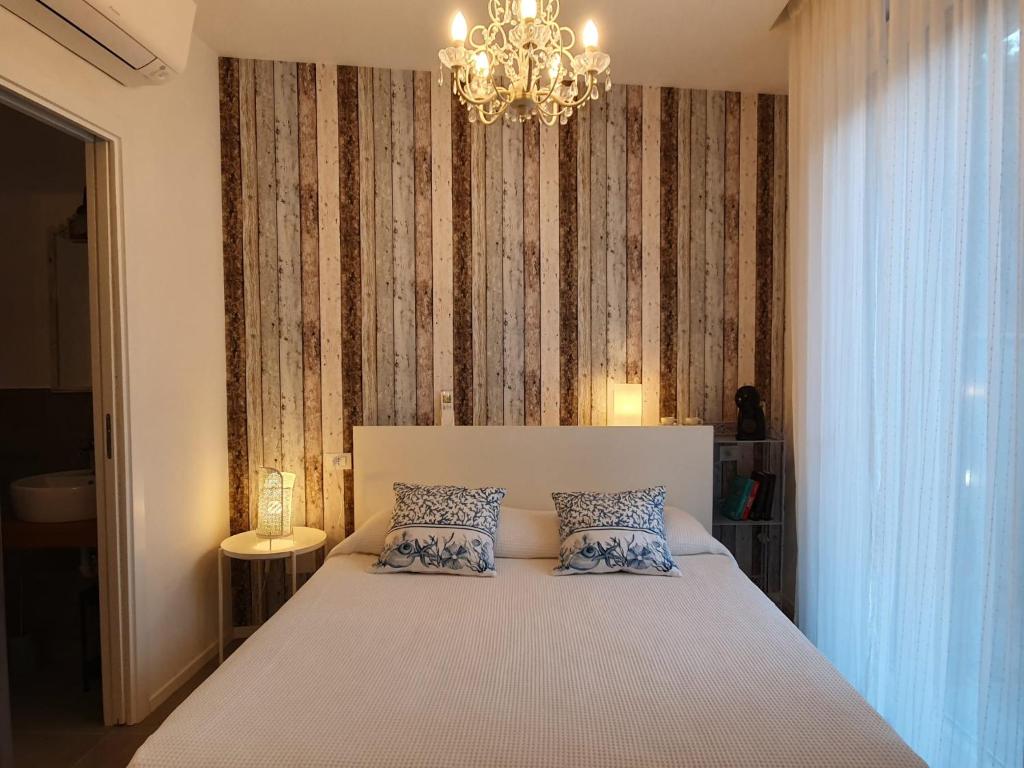 Residenza Azzurra في كاتوليكا: غرفة نوم بسرير مع ثريا