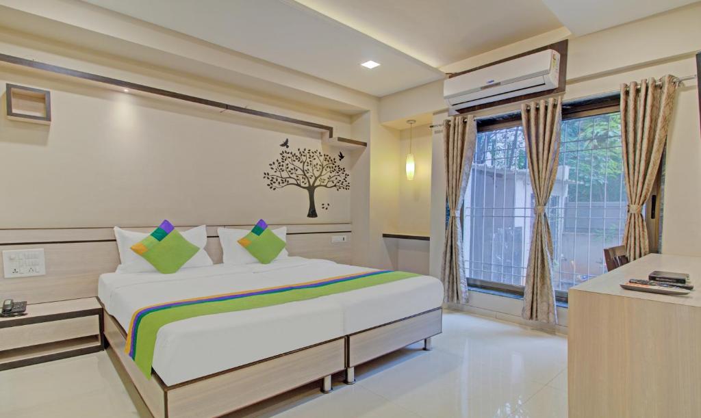 - une chambre avec un grand lit et une fenêtre dans l'établissement Treebo Trend Sumati Baner, à Méribel Village