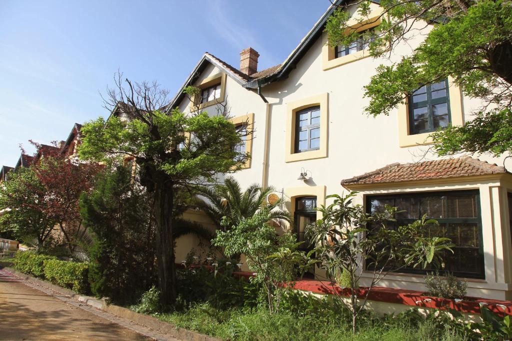 ein weißes Haus mit Bäumen davor in der Unterkunft Old England House in Minas de Ríotinto