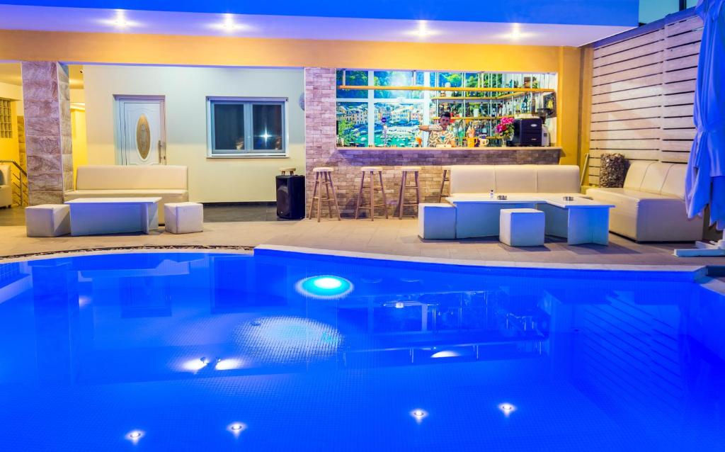 - un salon avec une piscine, une table et des chaises dans l'établissement ALDEBARAN HOMES, à Limenaria