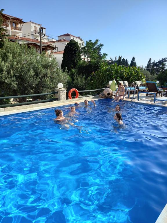 eine Gruppe von Personen, die in einem Schwimmbad schwimmen in der Unterkunft Villa Rena in Batsi