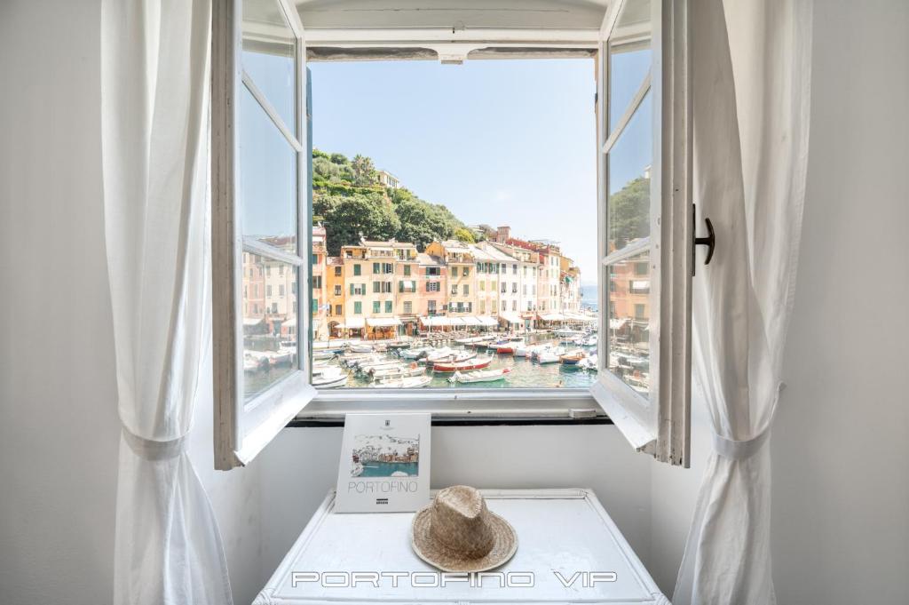 un chapeau assis sur une table devant une fenêtre dans l'établissement Angolo di mare by PortofinoVip, à Portofino