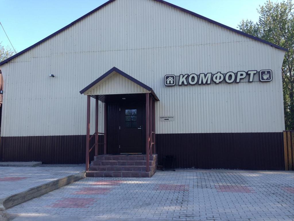 un gran edificio blanco con una puerta y un cartel en él en Mini-Hotel Comfort, en Suoyarvi