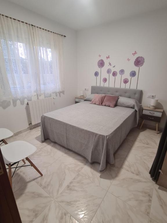 sypialnia z dużym łóżkiem z kwiatami na ścianie w obiekcie A Casa de Carmen w mieście Frije