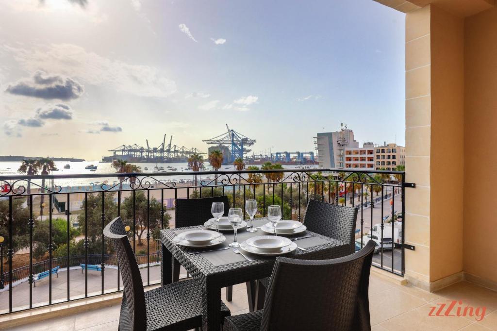 a table and chairs on a balcony with a view of the ocean at Luxurious Duplex Seafront Apt w Amazing Sea Views in Birżebbuġa