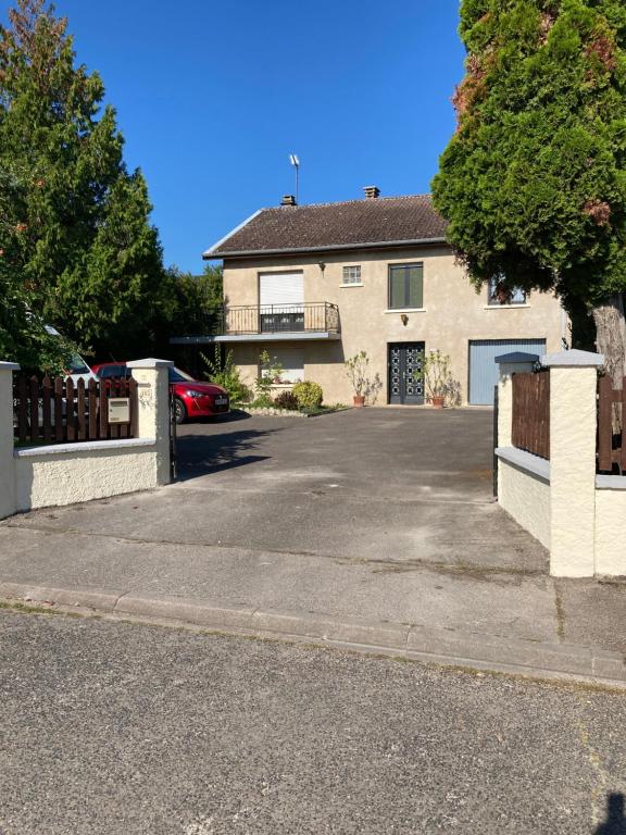 a house with a car parked in a driveway at L hotellerie de la gare in Bruley