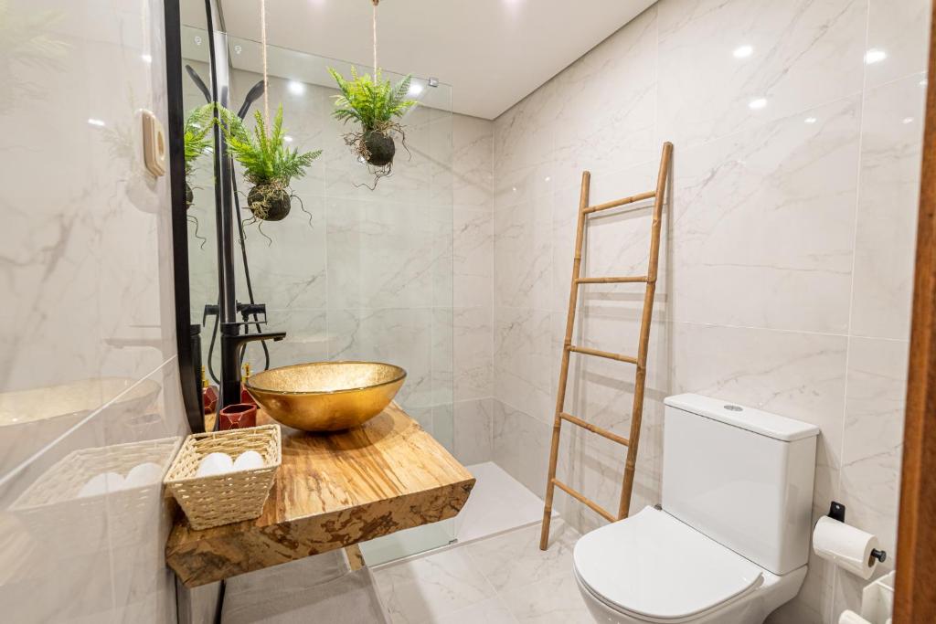 - une salle de bains avec un bol en bois sur une table en bois à côté des toilettes dans l'établissement Casas da Fonte - Turismo Rural, à Vila Verde